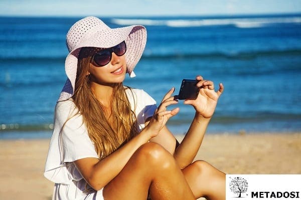 Une jeune femme sur la plage avec un téléphone portable, smartphone
