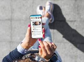 Femme utilisant l'application de microblogging des médias sociaux sur son téléphone photo